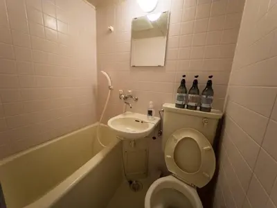 a bathroom with a toilet and a sink with bottles on it at Ichigaya Stay & Wi-Fi 1 in Tokyo