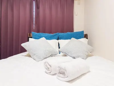 a bed with white pillows and towels on it at Ichigaya Stay & Wi-Fi 1 in Tokyo