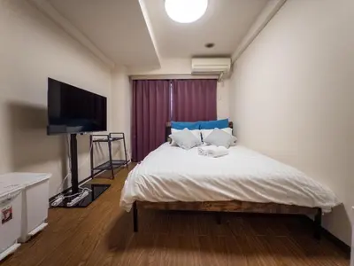 a bedroom with a bed and a flat screen tv at Ichigaya Stay & Wi-Fi 1 in Tokyo