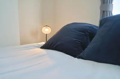 a bed with two blue pillows and a lamp at Contrail Room 203 - Vacation STAY 18527 in Tokyo