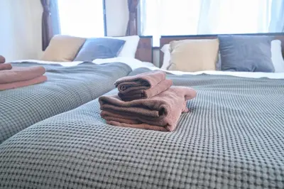 a pile of towels sitting on top of a bed at Contrail Room 203 - Vacation STAY 18527 in Tokyo