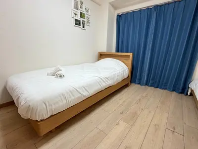 a bedroom with a bed and a blue curtain at YMK Oshiage 4B in Tokyo