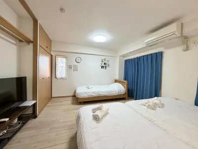 a hotel room with two beds and a flat screen tv at YMK Oshiage 4B in Tokyo