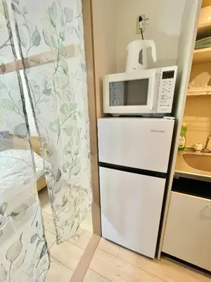 a microwave on top of a refrigerator in a kitchen at YMK Oshiage 4B in Tokyo