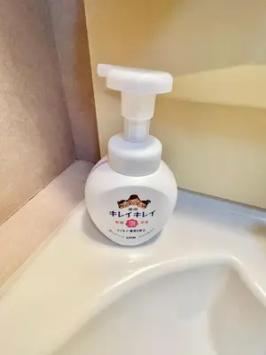 a bottle of moisturizing moisturizers sitting on top of a urinal at YMK Oshiage 4B in Tokyo