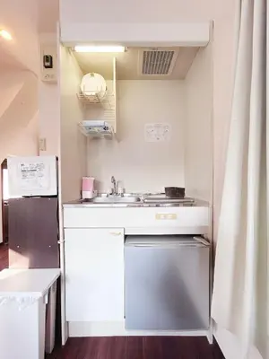 a small kitchen with a sink and a refrigerator at Ueno Sky Garden in Tokyo