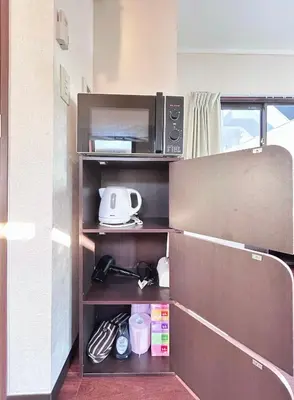 a kitchen with a microwave on a shelf at Ueno Sky Garden in Tokyo