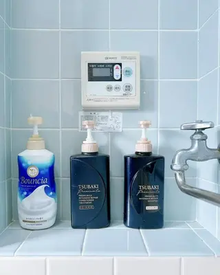 three bottles of detergent and a soap dispenser on a bathroom counter at Ueno Sky Garden in Tokyo
