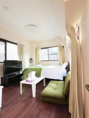 a bedroom with a bed and a couch and a tv at Ueno Sky Garden in Tokyo