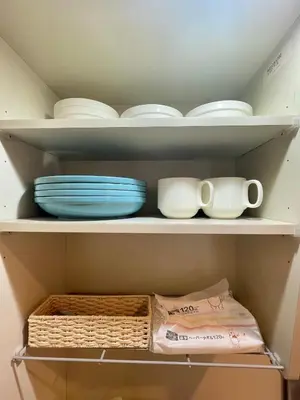 a shelf with plates and cups and bowls on it at YMK Oshiage 6B in Tokyo