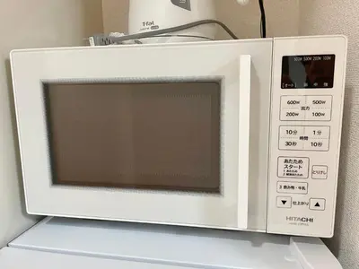 a white microwave oven sitting on top of a refrigerator at YMK Oshiage 7A in Tokyo