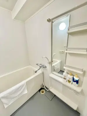 a bathroom with a tub and a sink and a mirror at YMK Oshiage 7A in Tokyo