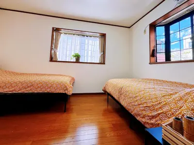 a bedroom with two beds and two windows at Mark\u7684\u5c0f\u5ca9\u6c11\u5bbf in Tokyo