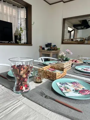 a table with plates and a glass vase on it at Mark\u7684\u5c0f\u5ca9\u6c11\u5bbf in Tokyo