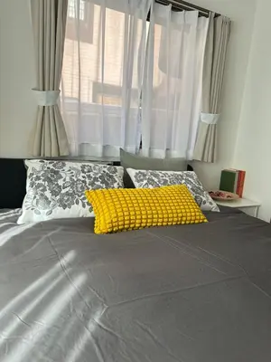 a bed with a yellow pillow and a window at Mark\u7684\u5c0f\u5ca9\u6c11\u5bbf in Tokyo