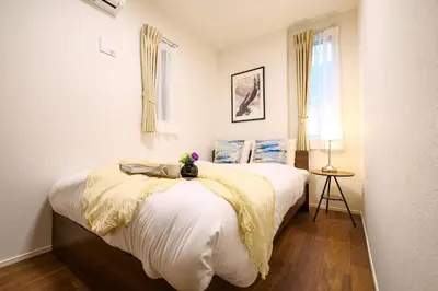 a bedroom with a large bed with white sheets at AS\u685c\u4e0a\u6c34Villa in Tokyo