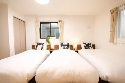 two white beds in a room with a window at AS\u685c\u4e0a\u6c34Villa in Tokyo