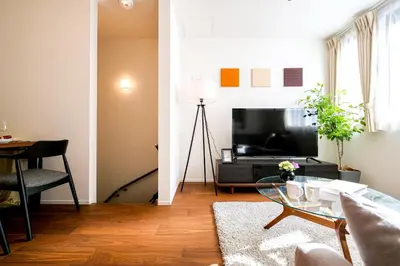 a living room with a table and a television at AS\u685c\u4e0a\u6c34Villa in Tokyo