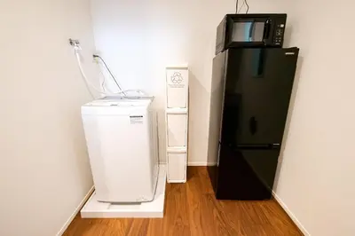 a microwave and a refrigerator in a room at AS\u685c\u4e0a\u6c34Villa in Tokyo