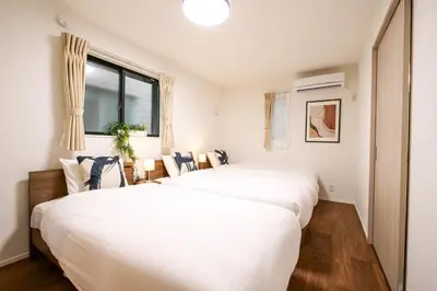 two white beds in a room with a window at AS\u685c\u4e0a\u6c34Villa in Tokyo