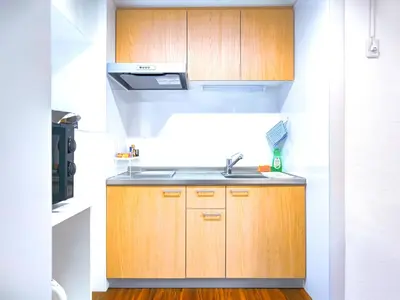 a kitchen with wooden cabinets and a sink at YayoiHotel in Tokyo