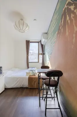 a bedroom with a bed and a table and chairs at Ikebukuro-Mejiro Good Place House in Tokyo