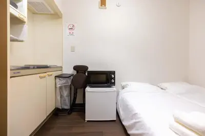 a bedroom with a bed and a small television at Ikebukuro-Mejiro Good Place House in Tokyo