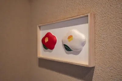 two vases on a light switch on a wall at LiveGRACE Hotel Asakusa \u6d45\u8349\u9685\u7530\u5ddd in Tokyo