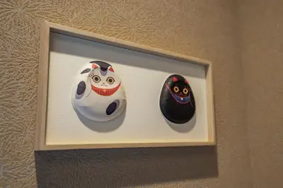 a picture of three masks on a wall at LiveGRACE Hotel Asakusa \u6d45\u8349\u9685\u7530\u5ddd in Tokyo