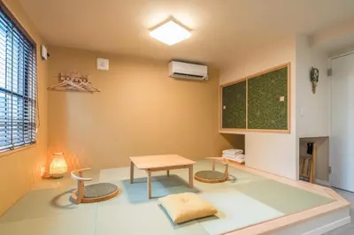 a room with a table and chairs and a desk at LiveGRACE Hotel Asakusa \u6d45\u8349\u9685\u7530\u5ddd in Tokyo