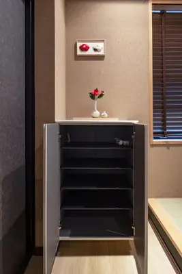 a dresser with a vase with a flower in it at LiveGRACE Hotel Asakusa \u6d45\u8349\u9685\u7530\u5ddd in Tokyo
