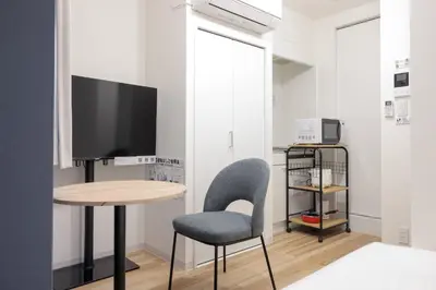 a room with a table and a chair and a television at CH RESiDENCE \u4e21\u56fd in Tokyo