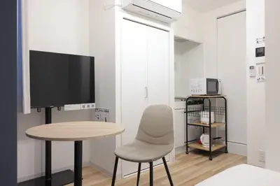 a living room with a table and a tv and a chair at CH RESiDENCE \u4e21\u56fd in Tokyo