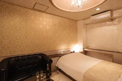a bedroom with a bed and a chair and a chandelier at Hotel en \u30db\u30c6\u30eb \u30a8\u30f3-Adult Only- in Tokyo