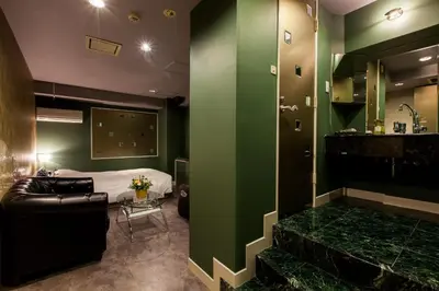 a hotel room with a bed and a green wall at Hotel en \u30db\u30c6\u30eb \u30a8\u30f3-Adult Only- in Tokyo