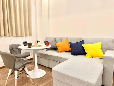 a living room with a gray couch with colorful pillows at Tokyo Life hotel in Tokyo