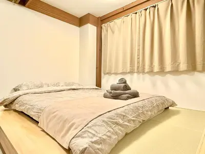 a teddy bear sitting on a bed in a bedroom at Tokyo Life hotel in Tokyo
