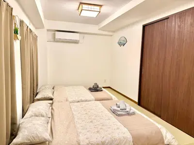 a bedroom with two beds and a closet at Tokyo Life hotel in Tokyo