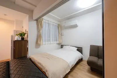 a bedroom with a bed and a chair at Hotel the World Omori 102 - Vacation STAY 19409v in Tokyo
