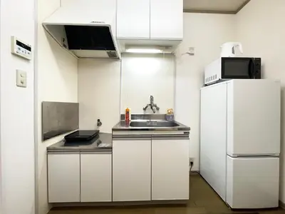 a small kitchen with a sink and a refrigerator at Japan House Ikebukuro Honcho in Tokyo