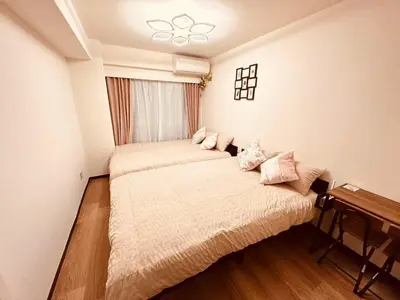 a bedroom with two beds and a window at Shinjuku Kabukicho \u65b0\u5bbf\u6700\u4e2d\u5fc3 \u6771\u65b0\u5bbf5\u5206 \u65b0\u5bbf9\u5206 MAX4\u4eba \u76f4\u9054 \u6e0b\u8c37\u539f\u5bbf\u4e0a\u91ce\u79cb\u8449\u539f in Tokyo