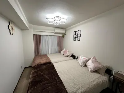 a small bedroom with two beds and a window at Shinjuku Kabukicho \u65b0\u5bbf\u6700\u4e2d\u5fc3 \u6771\u65b0\u5bbf5\u5206 \u65b0\u5bbf9\u5206 MAX4\u4eba \u76f4\u9054 \u6e0b\u8c37\u539f\u5bbf\u4e0a\u91ce\u79cb\u8449\u539f in Tokyo