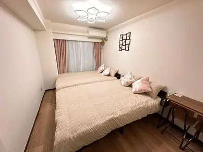 a bedroom with two beds and a window at Shinjuku Kabukicho \u65b0\u5bbf\u6700\u4e2d\u5fc3 \u6771\u65b0\u5bbf5\u5206 \u65b0\u5bbf9\u5206 MAX4\u4eba \u76f4\u9054 \u6e0b\u8c37\u539f\u5bbf\u4e0a\u91ce\u79cb\u8449\u539f in Tokyo