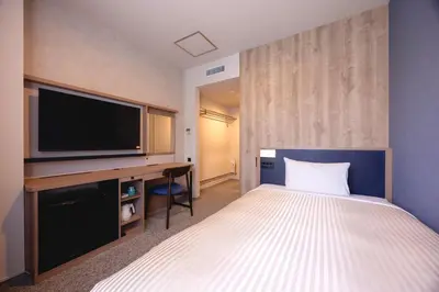 a hotel room with a bed and a flat screen tv at Hotel Mariners Court Tokyo in Tokyo