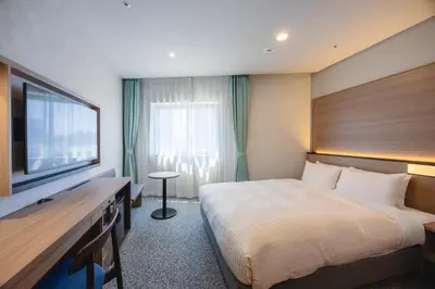 a hotel room with a bed and a flat screen tv at Hotel Mariners Court Tokyo in Tokyo