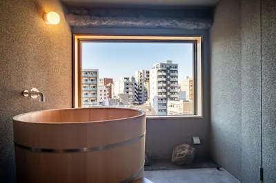 a bath tub in a room with a large window at Mi-Kan Design Hotel in Tokyo