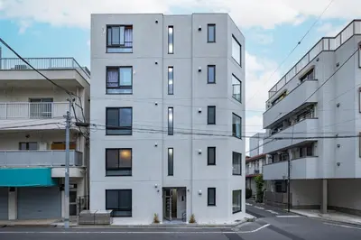 a white building with windows on a street at 67 Apt Waseda Shinjuku in Tokyo