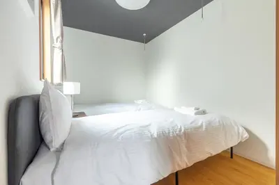 a bedroom with a white bed with a window at 67 Apt Waseda Shinjuku in Tokyo
