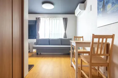 a living room with a couch and a table and chairs at 67 Apt Waseda Shinjuku in Tokyo