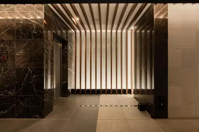 a hallway with black marble walls and a window at ROLES Ryusen 1001 in Tokyo